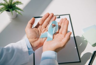 Cropped,View,Of,Doctor,Holding,Blue,Awareness,Ribbon,Near,Clipboard